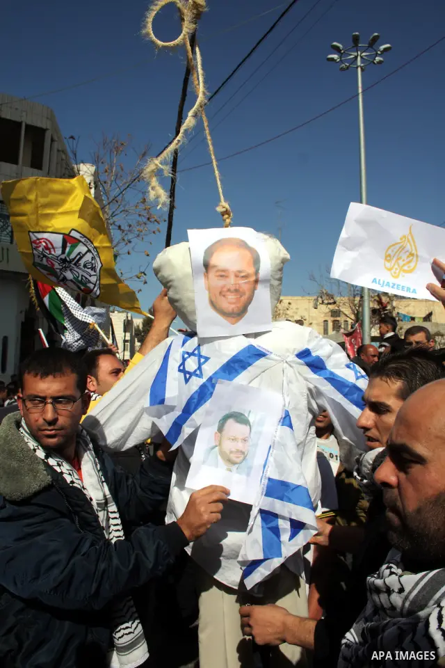 Palestinian Fatah supporters hold flags and signs during a rally supporting Palestinian President Mahmoud Abbas, and against Al-Jazeera, in the West Bank town of Hebron, Friday, Jan. 28, 2011. Al-Jazeera, a Qatar-based A...