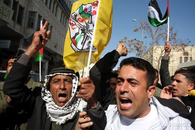 Palestinian Fatah supporters hold flags and signs during a rally supporting Palestinian President Mahmoud Abbas, and against Al-Jazeera, in the West Bank town of Hebron, Friday, Jan. 28, 2011. Al-Jazeera, a Qatar-based A...