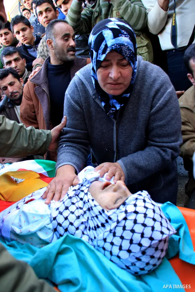 Palestinian mourners surround the body of Uday Qadous, 18, who was shot and killed Thursday in the village of Iraq Burin, during his funeral at in the West Bank city of Nablus, Friday Jan. 28, 2011. Israeli police spokes...