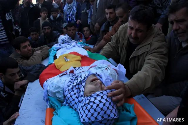 Palestinian mourners surround the body of Uday Qadous, 18, who was shot and killed Thursday in the village of Iraq Burin, during his funeral at in the West Bank city of Nablus, Friday Jan. 28, 2011. Israeli police spokes...