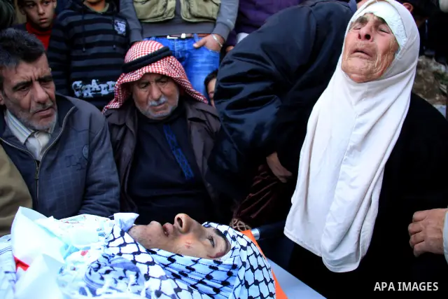 Palestinian mourners surround the body of Uday Qadous, 18, who was shot and killed Thursday in the village of Iraq Burin, during his funeral at in the West Bank city of Nablus, Friday Jan. 28, 2011. Israeli police spokes...