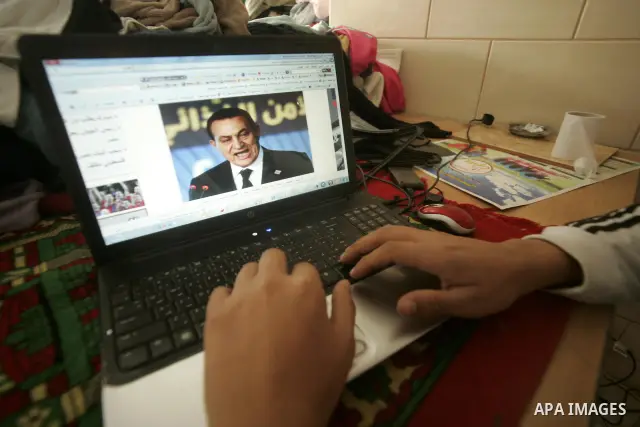 A Palestinian man looks at the computer to follow the hot events in Egypt, in Rafah, southern Gaza Strip on January 29, 2011. Protest demonstrations continued in central Cairo after the government-ordered overnight curfe...