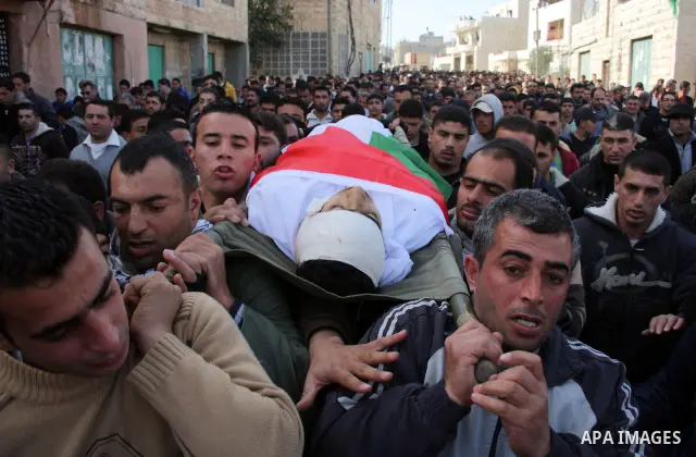Palestinians carry the body of Youssef Ekhaleil during his funeral in the West Bank village of Beit Omar, near Hebron, Saturday, Jan. 29, 2011. Ekhaleil died from wounds sustained during a clash with settlers on Friday P...