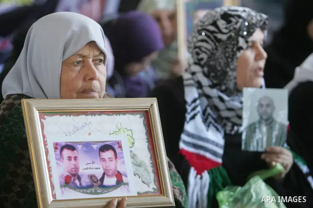 Palestinian women and children hold pictures of jailed relatives during a protest calling for the release of Palestinian prisoners from Israeli jails at the Red Cross office in Gaza City on Jan. 31, 2011. Photo by Mohamm...