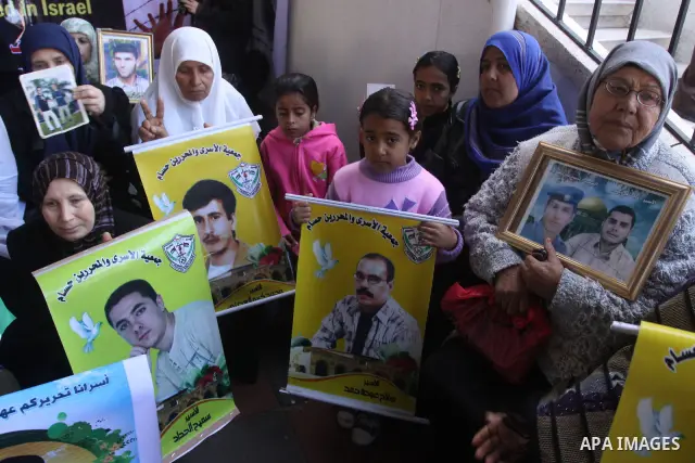 Palestinian women and children hold pictures of jailed relatives during a protest calling for the release of Palestinian prisoners from Israeli jails at the Red Cross office in Gaza City on Jan. 31, 2011. Photo by Mohamm...