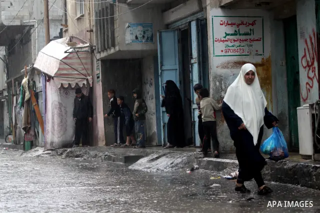 Palestinians walk in a rain flooded street at the Shati refugee camp in Gaza City, Tuesday, Feb. 1 , 2011.. Photo by Mohammed Asad