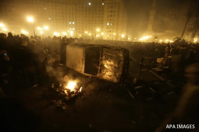 Egyptian protesters walk past fires lit at the doors of the ruling National Democratic Party (NDP) headquarters after demonstrations erupted following Friday prayers in Cairo, Egypt, 28 January 2011. Photo by Karam Nasse...