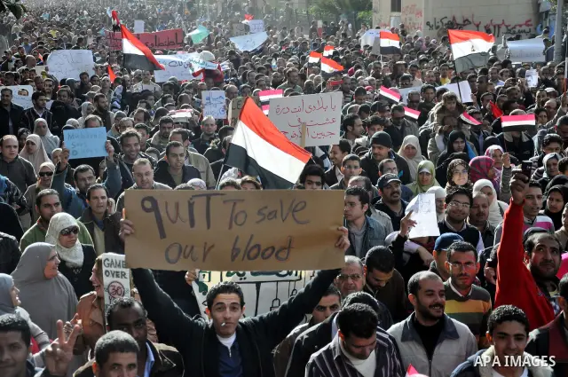 Anti-government demonstrators march in Alexandria, Egypt, Tuesday, Feb.1, 2011. Egyptian President Hosni Mubarak defied a quarter-million protesters demanding he step down immediately, announcing he would serve out the l...