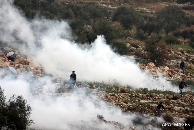 Israeli sildiers fire tear gas canisters towards Palestinian protesters during a protest in the village of Bilin on Feb. 4, 2011. Photo by Issam Rimawi