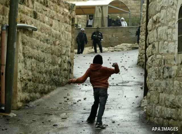Palestinian youths throw stones towards Israeli border police during clashes in the East Jerusalem neighbourhood of Ras al-Amud on February 04, 2011. Photo by Mahfouz Abu Turk