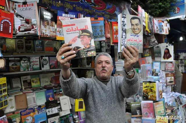 Egyptian man holds books for former Egyptian presidents Jamal Abed Al-Nasser and Anwar Al-Saddat at his bookshop in Alexandria, Egypt, 06 February 2011. Anti-government protests entered its 13th straight day in Egypt, as...