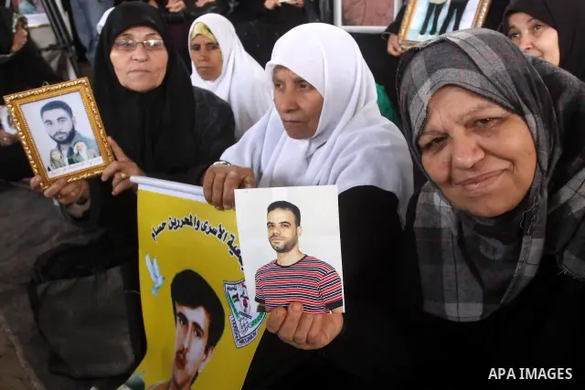 Palestinian women hold pictures of jailed relatives during a protest calling for the release of Palestinian prisoners from Israeli jails at the Red Cross office in Gaza City on Feb. 7,2011. Photo by Mohammed Asad