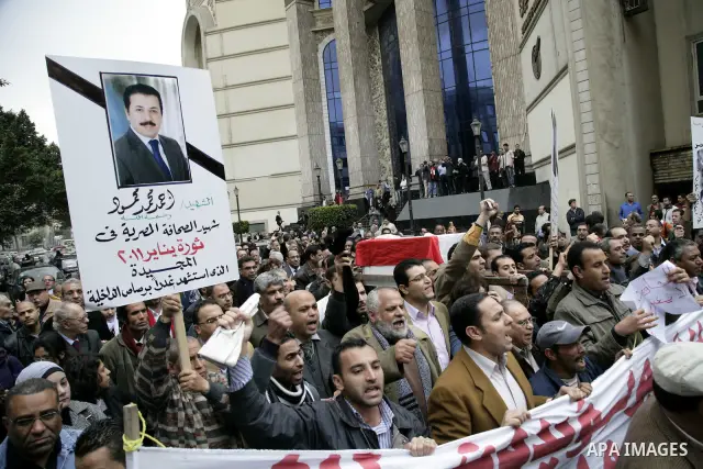 People carry a symbolic coffin of Egyptian journalist Ahmed Mohammed Mahmoud, in symbolic funeral ceremony in Tahrir Square, Cairo, Egypt, Monday, Feb. 7, 2011. The reporter who was shot during clashes a week ago died of...