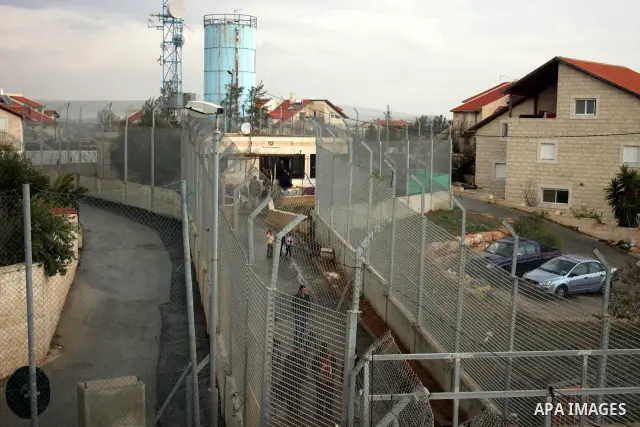Palestinians are seen in the fenced in back yard of the Sabri Gareeb family home which is situated in the center of the Givon Ha Hadasha Jewish settlement just south of Ramallah in the Israeli occupied West Bank on Febru...