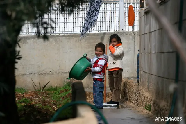 Palestinians are seen in the fenced in back yard of the Sabri Gareeb family home which is situated in the center of the Givon Ha Hadasha Jewish settlement just south of Ramallah in the Israeli occupied West Bank on Febru...