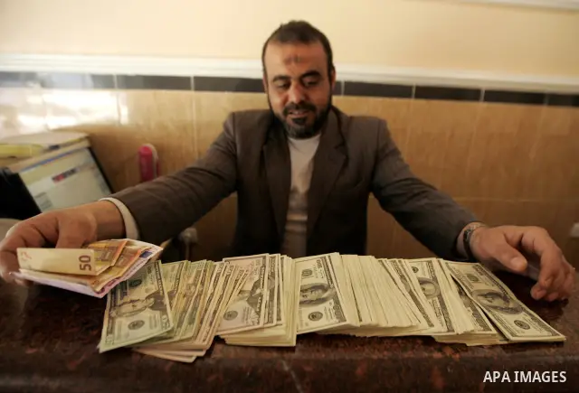 A Palestinian man displays money at his exchanges currency shop in the southern Gaza Strip town of Rafah on Feb. 2011. Photo by Abed Rahim Khatib