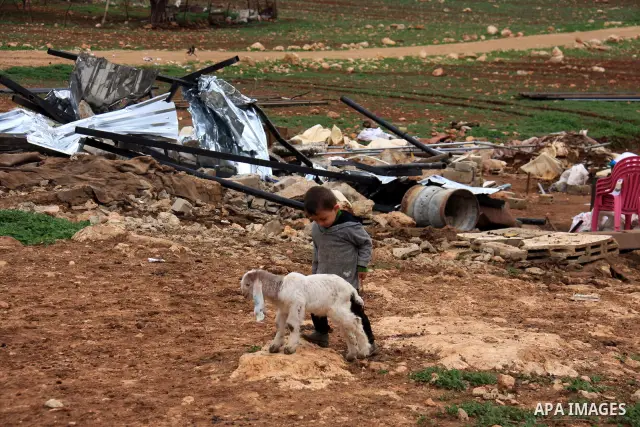 A Palestinian boy walks after the Civil Administration demolished constructions in the village of Khirbet Tana near the West Bank city of Nablus, Wednesday, Feb. 9, 2011. According to Palestinian witnesses and an Israeli...