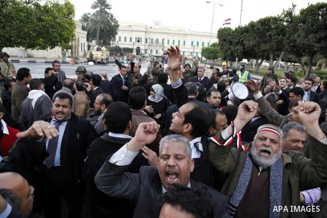 Egyptian protesters demonstrate at the gate of the presidential palace in Cairo, Egypt, Thursday, Feb. 10, 2011. Egypt's foreign minister warns of a military coup if protesters continue mass demonstrations and don't foll...
