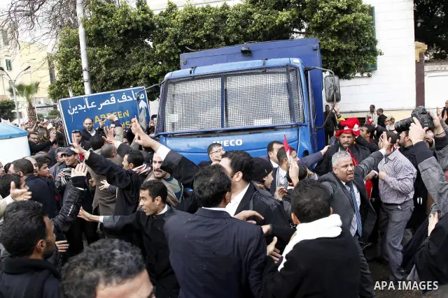 Egyptian protesters demonstrate at the gate of the presidential palace in Cairo, Egypt, Thursday, Feb. 10, 2011. Egypt's foreign minister warns of a military coup if protesters continue mass demonstrations and don't foll...