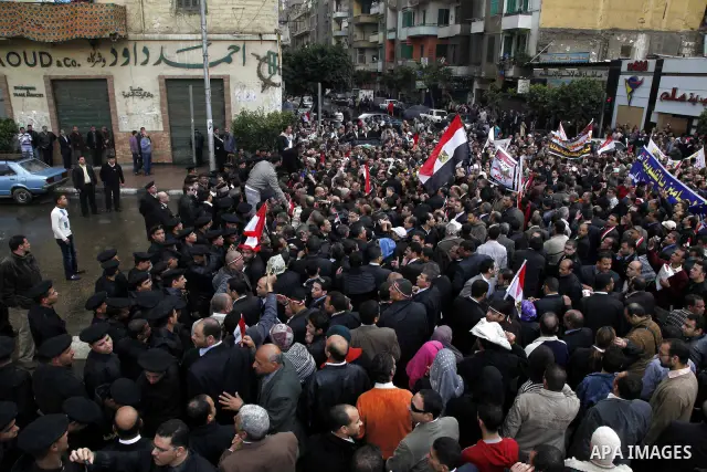 Egyptian protesters demonstrate at the gate of the presidential palace in Cairo, Egypt, Thursday, Feb. 10, 2011. Egypt's foreign minister warns of a military coup if protesters continue mass demonstrations and don't foll...
