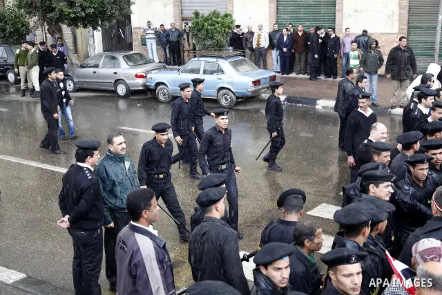 Egyptian policemen stands guard as protesters demonstrate at the gate of the presidential palace in Cairo, Egypt, Thursday, Feb. 10, 2011. Egypt's foreign minister warns of a military coup if protesters continue mass dem...