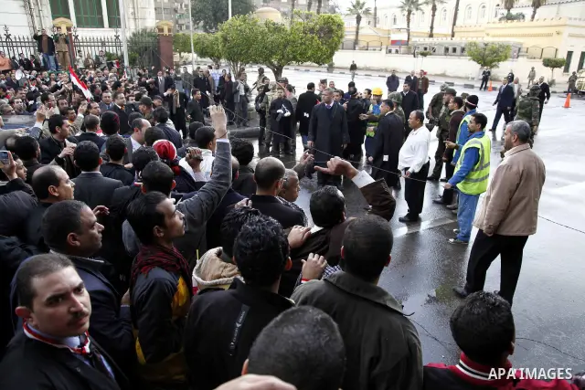 Egyptian protesters demonstrate at the gate of the presidential palace in Cairo, Egypt, Thursday, Feb. 10, 2011. Egypt's foreign minister warns of a military coup if protesters continue mass demonstrations and don't foll...