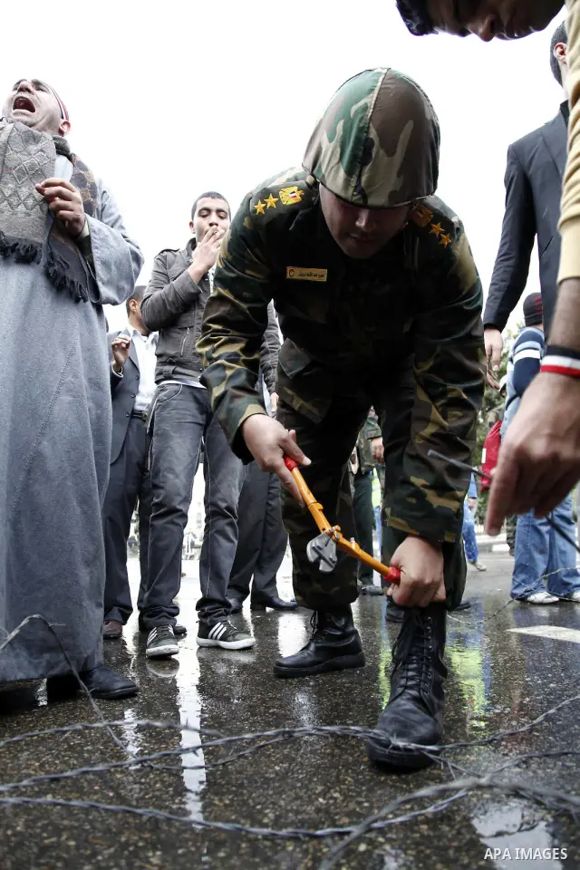 Egyptian protesters demonstrate at the gate of the presidential palace in Cairo, Egypt, Thursday, Feb. 10, 2011. Egypt's foreign minister warns of a military coup if protesters continue mass demonstrations and don't foll...