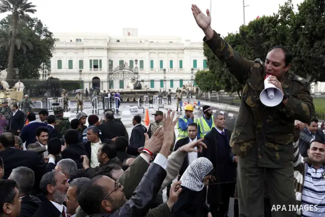 Egyptian protesters demonstrate at the gate of the presidential palace in Cairo, Egypt, Thursday, Feb. 10, 2011. Egypt's foreign minister warns of a military coup if protesters continue mass demonstrations and don't foll...