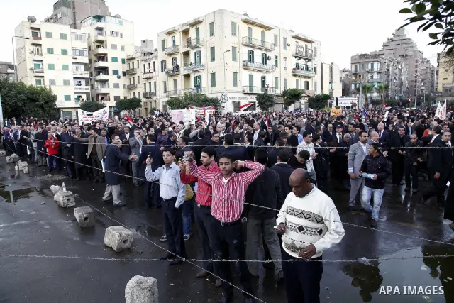 Egyptian protesters demonstrate at the gate of the presidential palace in Cairo, Egypt, Thursday, Feb. 10, 2011. Egypt's foreign minister warns of a military coup if protesters continue mass demonstrations and don't foll...