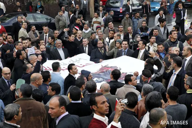 Egyptian protesters demonstrate at the gate of the presidential palace in Cairo, Egypt, Thursday, Feb. 10, 2011. Egypt's foreign minister warns of a military coup if protesters continue mass demonstrations and don't foll...