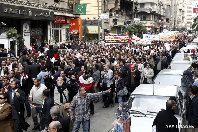 Egyptian protesters demonstrate at the gate of the presidential palace in Cairo, Egypt, Thursday, Feb. 10, 2011. Egypt's foreign minister warns of a military coup if protesters continue mass demonstrations and don't foll...