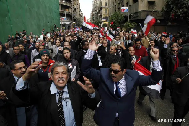 Egyptian protesters demonstrate at the gate of the presidential palace in Cairo, Egypt, Thursday, Feb. 10, 2011. Egypt's foreign minister warns of a military coup if protesters continue mass demonstrations and don't foll...