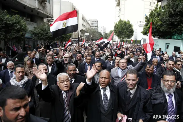 Egyptian protesters demonstrate at the gate of the presidential palace in Cairo, Egypt, Thursday, Feb. 10, 2011. Egypt's foreign minister warns of a military coup if protesters continue mass demonstrations and don't foll...
