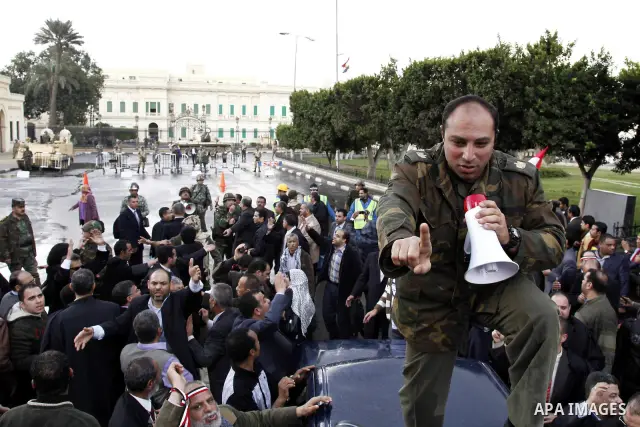 Egyptian protesters demonstrate at the gate of the presidential palace in Cairo, Egypt, Thursday, Feb. 10, 2011. Egypt's foreign minister warns of a military coup if protesters continue mass demonstrations and don't foll...