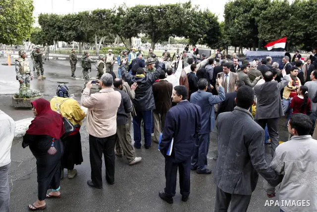 Egyptian protesters demonstrate at the gate of the presidential palace in Cairo, Egypt, Thursday, Feb. 10, 2011. Egypt's foreign minister warns of a military coup if protesters continue mass demonstrations and don't foll...