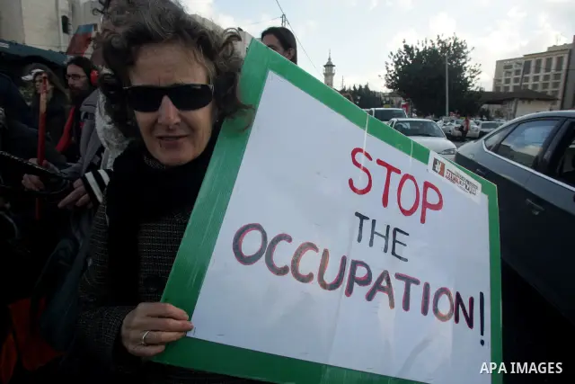 Palestinians, Israelis and foreign activists hold signs during a protest to show solidarity with Palestinian families against a Jewish settlement in the Sheikh Jarrah neighbourhood in East Jerusalem on Feb. 11, 2011. Pho...