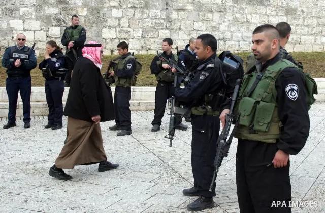 A Palestinian man walks past Israeli soldiers outside the Al-Aqsa Mosque compound in Jerusalem's Old City on February 11, 2011. Photo by Mahfouz Abu Turk