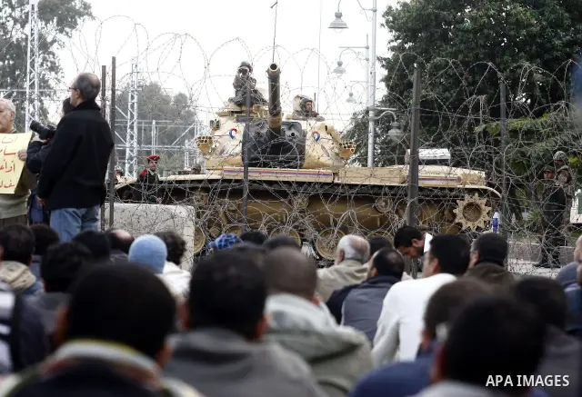 Egyptian protesters pray as the army block the entrence to Ettehadyya Presidential palace by barbed wire in Cairo, Egypt, Friday, Feb. 11, 2011. Egypt's military seemed to throw its weight Friday behind President Hosni M...