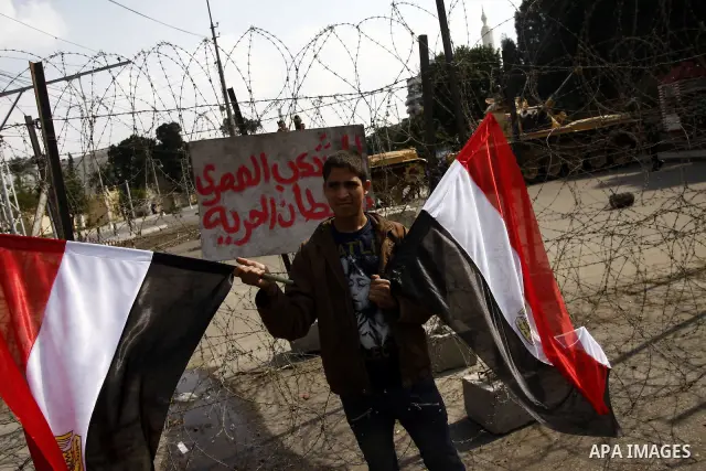 Anti-government protesters gather in front of Army soldiers protecting an entrance the entrence to Ettehadyya Presidential palace in Cairo, Egypt, Friday, Feb. 11, 2011. Egypt's military seemed to throw its weight Friday...