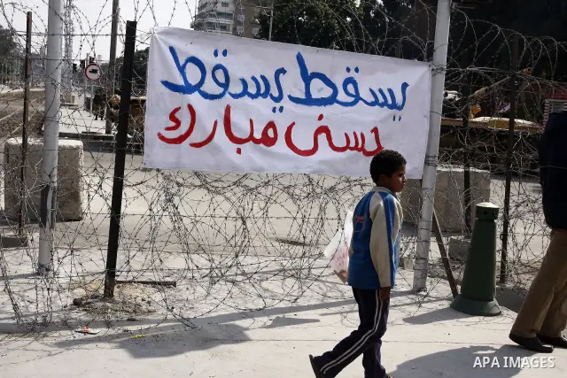 Anti-government protesters gather in front of Army soldiers protecting an entrance the entrence to Ettehadyya Presidential palace in Cairo, Egypt, Friday, Feb. 11, 2011. Egypt's military seemed to throw its weight Friday...