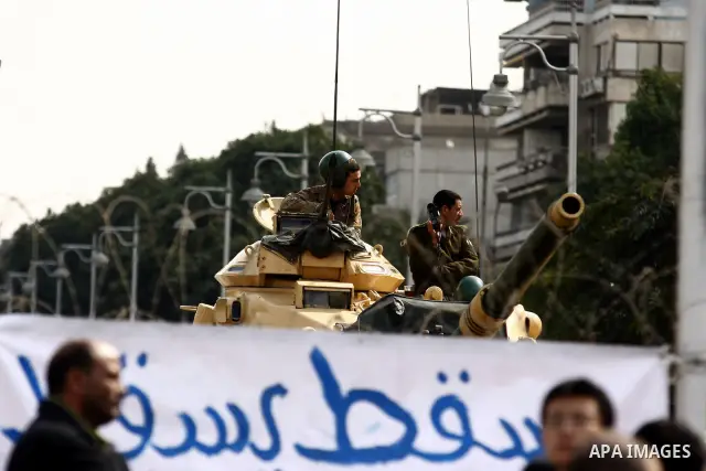 Anti-government protesters gather in front of Army soldiers protecting an entrance the entrence to Ettehadyya Presidential palace in Cairo, Egypt, Friday, Feb. 11, 2011. Egypt's military seemed to throw its weight Friday...