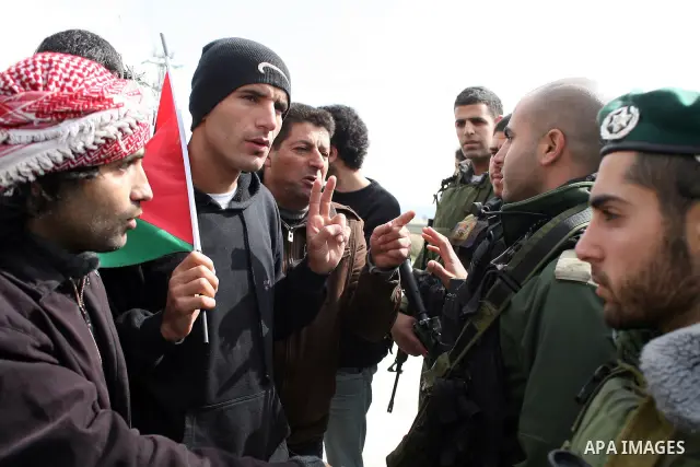Israeli soldiers restrain Palestinian ,Israeli and foreign protesters during a protest against Israel's controversial separation barrier in the West Bank village of Massarah,near the biblical town of Bethlehem, on Februa...