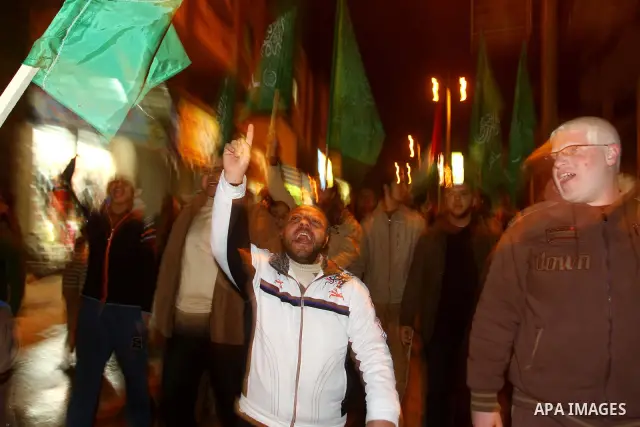 Palestinian Hamas supporters celebrate the news of the resignation of President Hosni Mubarak, who handed control of the country to the military, at night in Deir al-Balah in the central Gaza Strip, Friday, Feb. 11, 2011...