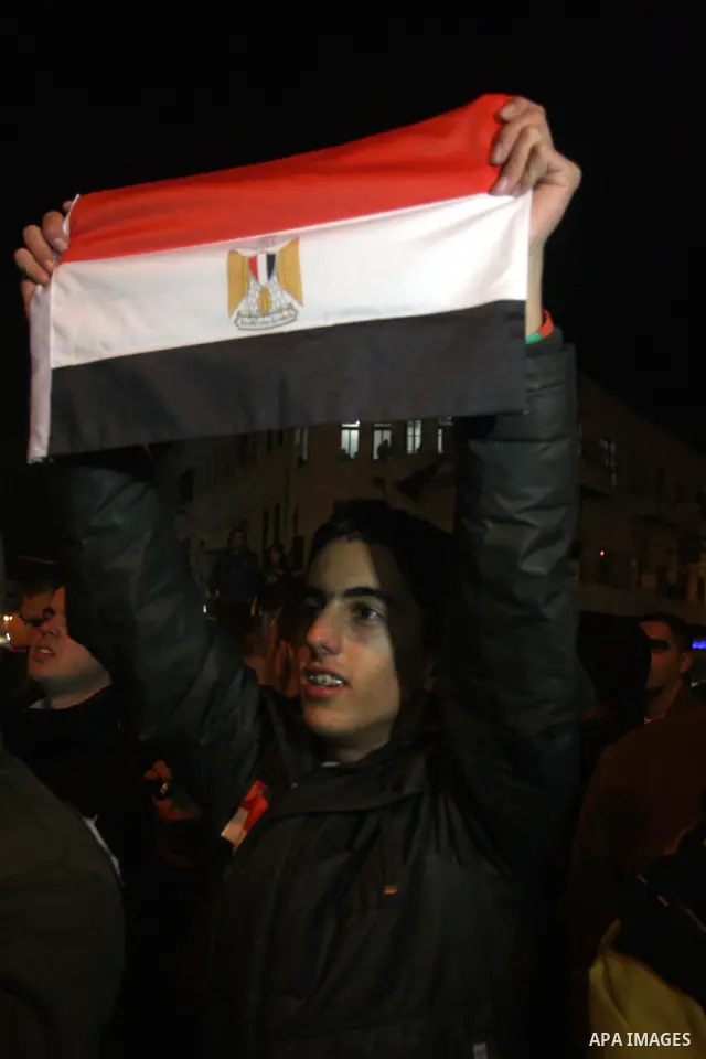 Palestinians celebrate the news of the resignation of President Hosni Mubarak, who handed control of the country to the military, at night in the West Bank city of Ramallah, Friday, Feb. 11, 2011. Photo by Issam Rimawi