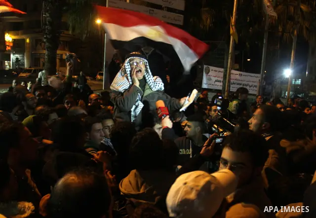 Palestinians celebrate the news of the resignation of President Hosni Mubarak, who handed control of the country to the military, at night in the West Bank city of Ramallah, Friday, Feb. 11, 2011. Photo by Issam Rimawi