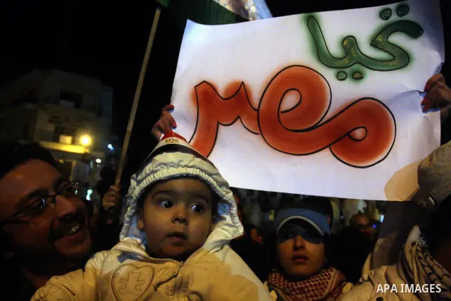 Palestinians celebrate the news of the resignation of President Hosni Mubarak, who handed control of the country to the military, at night in the West Bank city of Ramallah, Friday, Feb. 11, 2011. Photo by Issam Rimawi