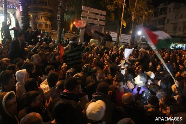 Palestinians celebrate the news of the resignation of President Hosni Mubarak, who handed control of the country to the military, at night in the West Bank city of Ramallah, Friday, Feb. 11, 2011. Photo by Issam Rimawi