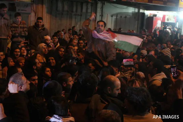 Palestinians celebrate the news of the resignation of President Hosni Mubarak, who handed control of the country to the military, at night in the West Bank city of Ramallah, Friday, Feb. 11, 2011. Photo by Issam Rimawi