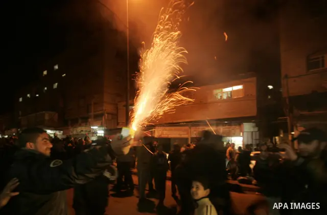 Palestinians celebrate the news of the resignation of President Hosni Mubarak, who handed control of the country to the military, at night in Rafah, southern Gaza Strip, Friday, Feb. 11, 2011. Photo by Abed Rahim Khatib