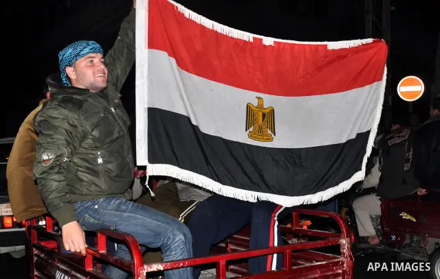 Palestinians celebrate the news of the resignation of President Hosni Mubarak, who handed control of the country to the military, at night in Rafah, southern Gaza Strip, Friday, Feb. 11, 2011. Photo by Abed Rahim Khatib